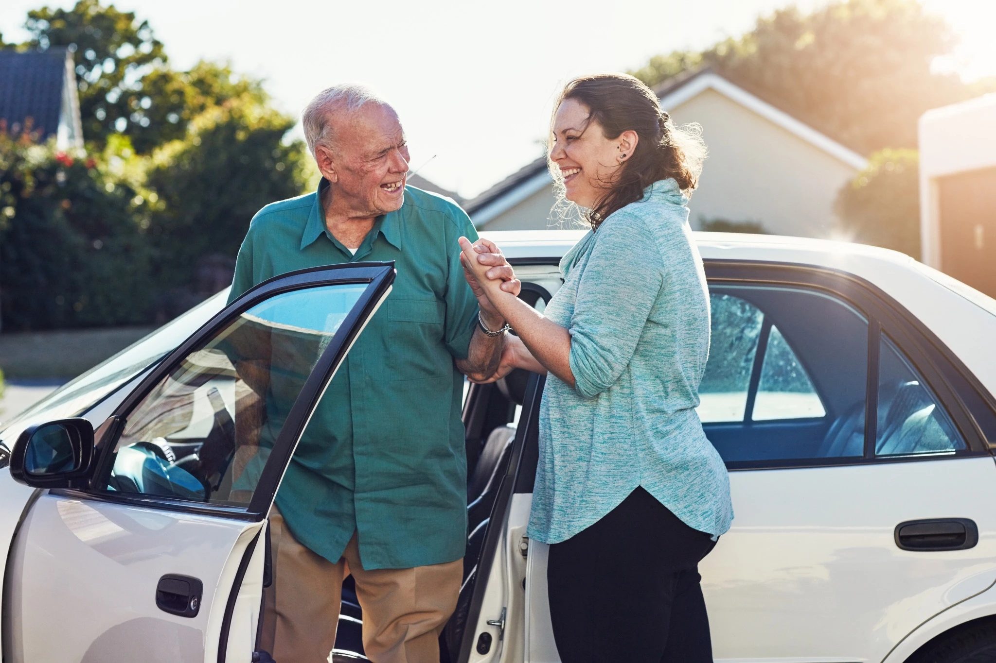 Care coordinator helping a patient near a car